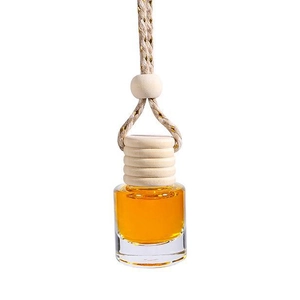 Car perfume glass bottle pendant with yellow liquid and wooden lid on white background