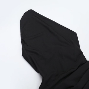 Gros plan sur la texture du tissu noir et le détail de la capuche de cette robe