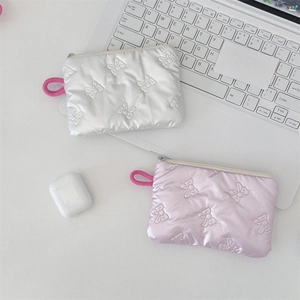 Close-up of quilted satin zipper pouches with 3D bow patterns in pink and silver