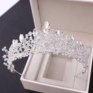 Detailed view of handcrafted silver bridal crown with crystals in a white jewelry box