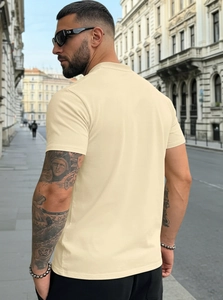 Macro shot of men's beige Henley shirt showing textured cotton fabric and back fit