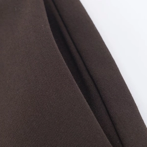 Gros plan montrant les détails de la texture du tissu sergé marron foncé du costume