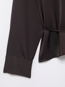 Close-up of deep-toned satin shirt cuffs with smooth texture and clean stitching