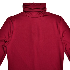 Détail du tissu rouge lisse et des coutures d'une robe à manches longues et col montant