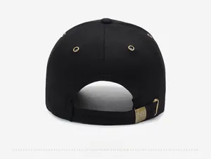 Detail of black cotton baseball cap rear with adjustable gold metal buckle and engraving
