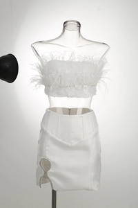 Close-up of white sequined top with ostrich feathers and rhinestone slit skirt