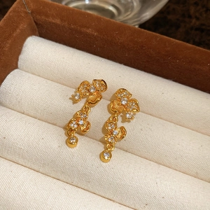 Macro shot of gold plated flower earrings with sparkling zircons in a jewelry box