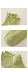 Detail view of the elastic rolled cuff, reinforced toe, and 3D heel of the green cotton sock