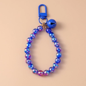 Detail of blue iridescent beads ring with matching metal bell and keychain hook charm