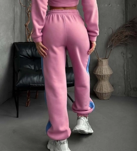 Dettaglio dei pantaloni sportivi rosa e blu con polsini elastici e morbida maglia