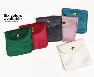 Flat lay of velvet jewelry pouches in six colors with golden snap button closures