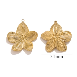 Close-up of 31mm golden flower charms with detailed radial texture and 3D stamens