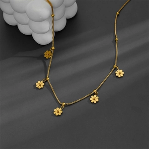 Detailed view of a gold floral tassel necklace with zircon charms on a delicate chain