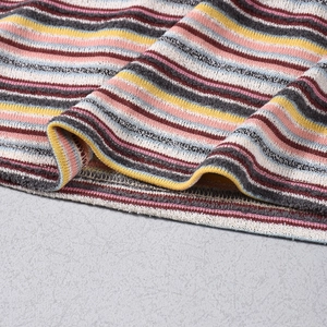 Close-up of knit fabric detail showing colorful stripes and fine hem stitching quality