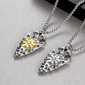 Close-up of Viking arrow pendants with compass engraving in silver and gold steel
