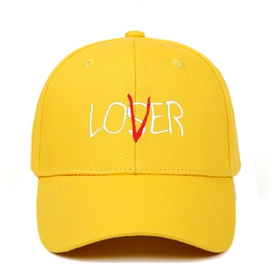 Detail of creative LOSER and LOVER white embroidery on yellow cotton baseball cap