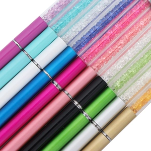 Macro view of colorful eyelash brushes with sparkling crystal filled handles on white