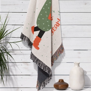 Detail of bohemian knit throw blanket featuring winter cartoon dwarf and fringe tassels