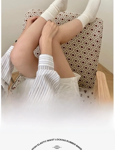 Detailed knit texture of white vertical stripe crew socks with high elastic cuffs