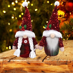 Paire de gnomes de Noël rouges à paillettes avec tresses et barbe sur surface en bois
