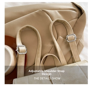 Detail shot of the adjustable shoulder strap with silver metal buckle on a beige bag