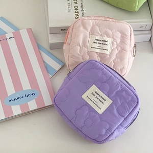 Close-up of pink and purple quilted floral coin purses with soft macaron fabric details