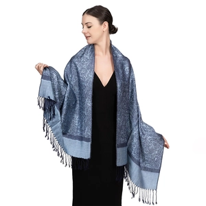 Detail shot of luxury blue paisley scarf with intricate jacquard weave and dark blue fringes