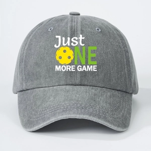 Close-up of Just One More Game embroidery and yellow pickleball on gray washed denim cap