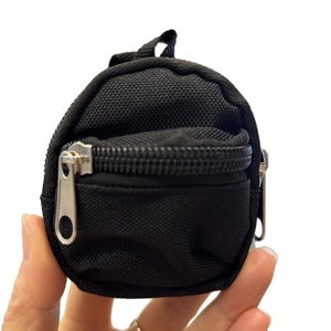 Hand holding a mini black backpack coin purse keychain with zipper and hanging loop