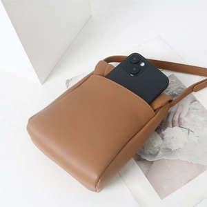 Gros plan détaillé du sac à téléphone en cuir PU marron avec bandoulière fine