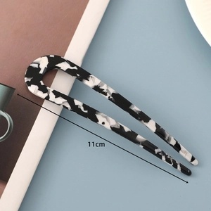 Detail of minimalist U-shaped hair pin with 11cm length and marble pattern texture