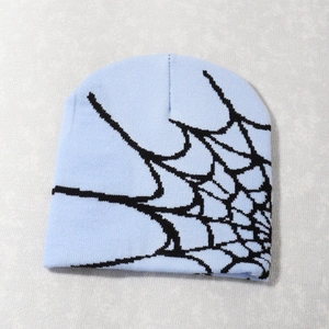 Close-up of tight knit texture and black spider web pattern on the light blue beanie