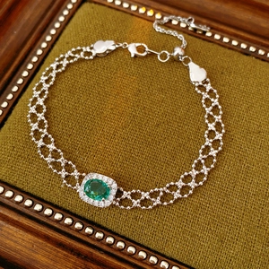 Detailed macro view of vintage silver bracelet with green oval stone and zircon halo