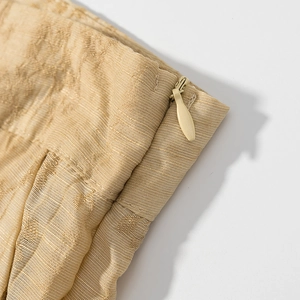 Detail shot of golden brown jacquard fabric with a high-quality invisible zipper closure
