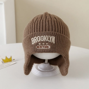 Dettaglio del cappello in maglia marrone con ricamo Brooklyn e paraorecchie caldi