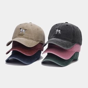 Detail view of vintage washed cotton baseball caps with dog embroidery in six colors