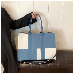 Macro detail of large blue and white patchwork denim tote bag with versatile straps