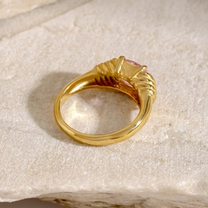 Macro detail of 18k gold croissant ring featuring a sparkling oval pink gemstone inlay