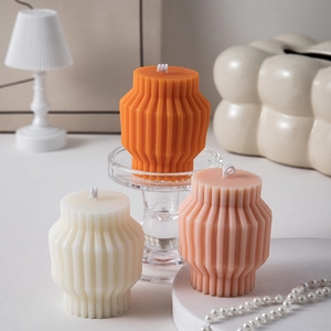 Detailed view of geometric pleated candles with elegant pearl necklace and home decor