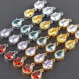 Macro view of teardrop glass charms with 18k gold plating in various colors