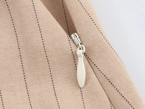 Vue macro de la fermeture éclair invisible sur l'ensemble en lin et coton à rayures beige