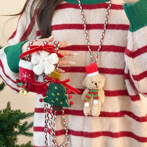 Detail of Christmas flocking dolls on a festive woven necklace for winter fashion
