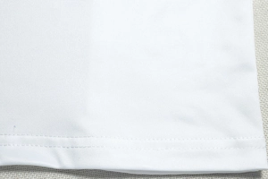 Gros plan détaillé de l'ourlet à double couture et texture tricotée d'une robe blanche