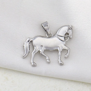 Detailed silver horse pendant with intricate saddle and bridle on soft silk fabric