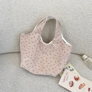 Close-up of pink corduroy tote bag with brown floral pattern on fleece background