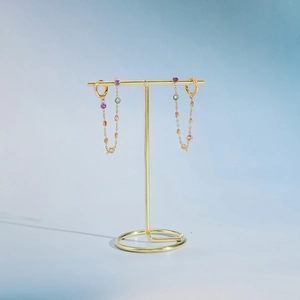 Macro shot of 18k gold earrings featuring colorful tassels and vibrant zircon gemstones