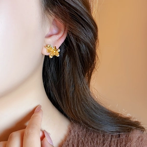 Gros plan de boucles d'oreilles irrégulières plaquées or 18k portées par un mannequin