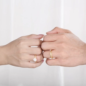 Elegant gold-tone CZ couple rings set shown on hands with minimalist wedding style