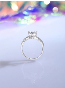 Macro detail of crown ring with round 8A zircon and silver pavé setting on purple background