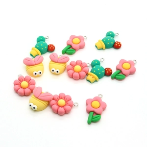 Macro view of DIY charms featuring resin honeybees, flowers, and cacti with metal rings